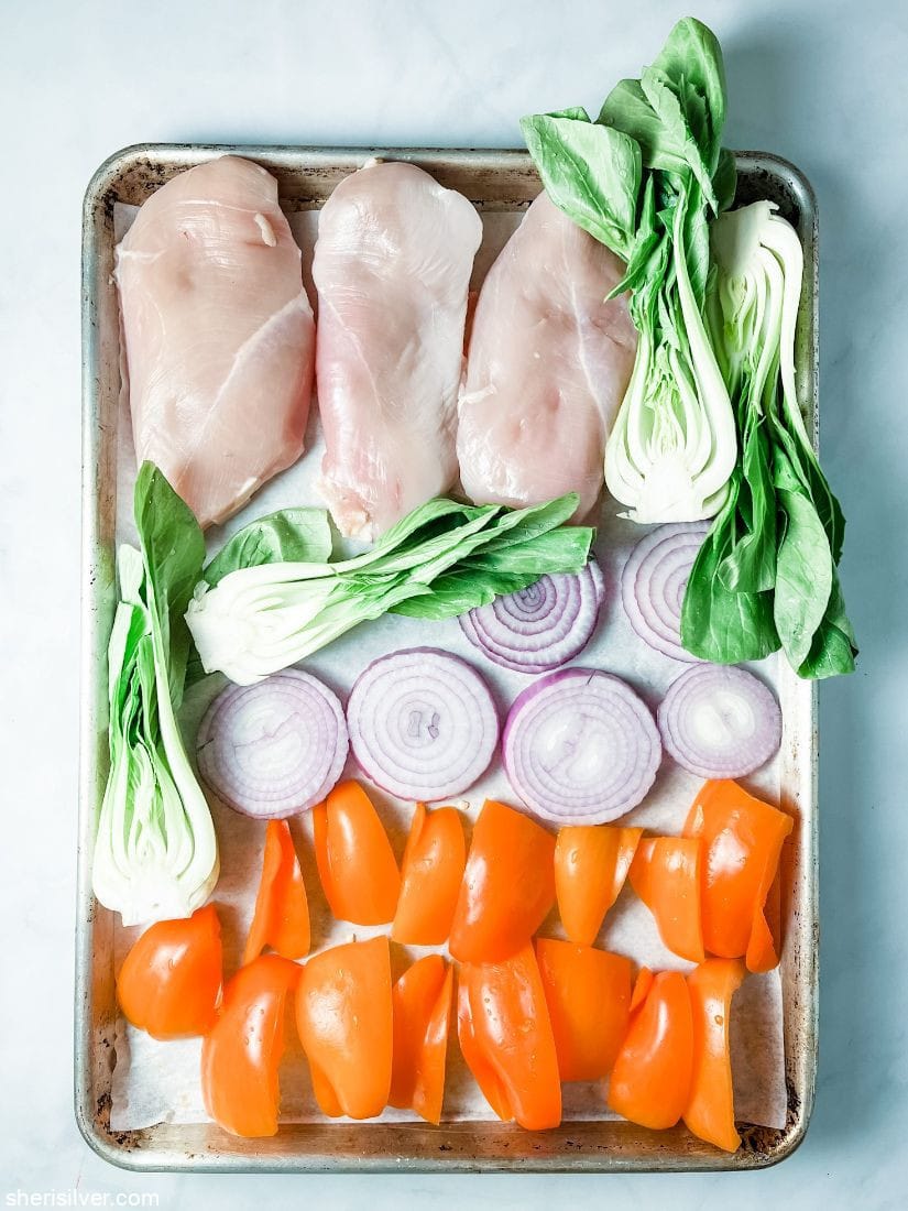 chicken breasts with vegetables on a sheet pan