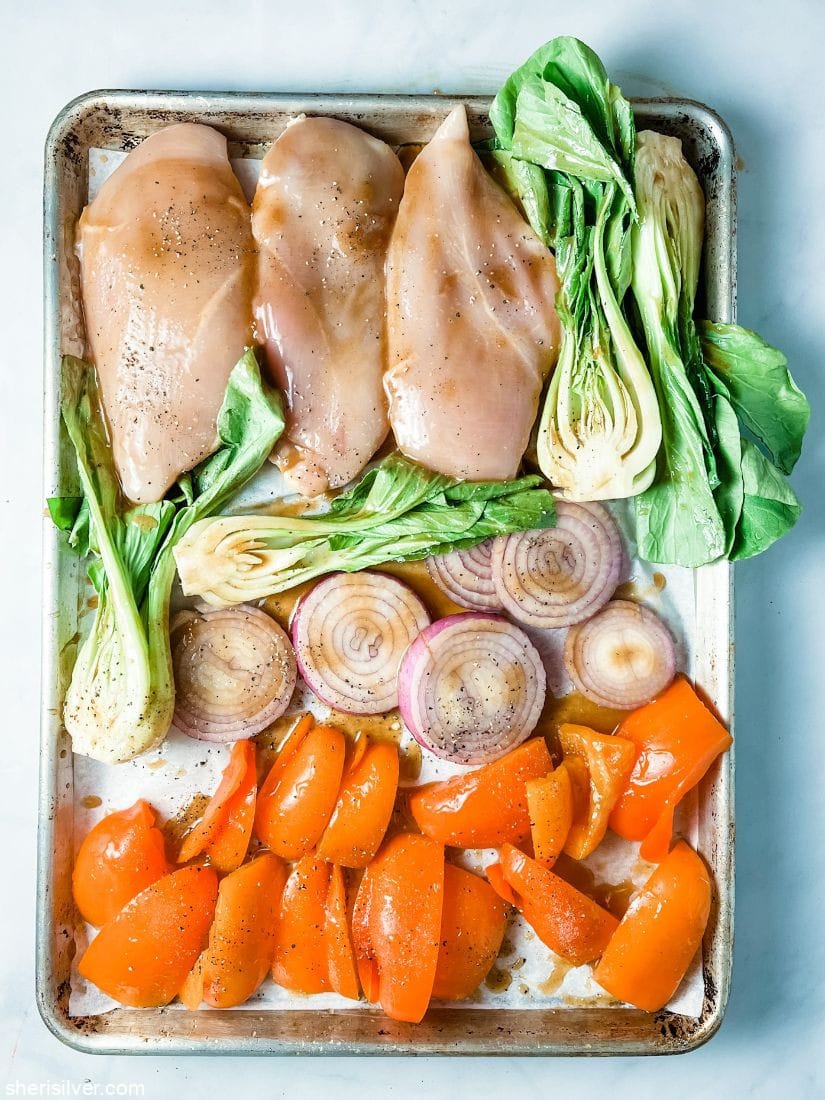 chicken breasts with vegetables on a sheet pan