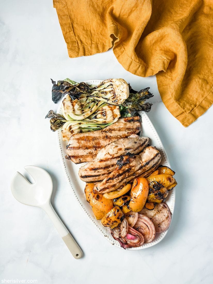 grilled chicken and vegetables on a white ceramic platter