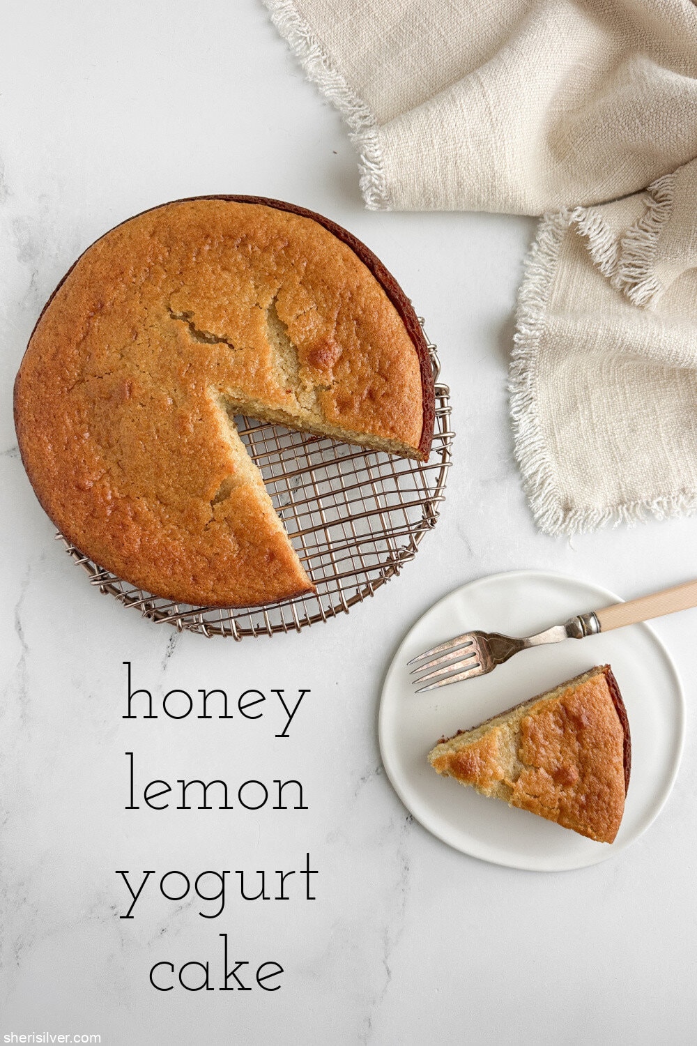 Honey lemon yogurt cake with a slice cut out and served on a white plate with vintage fork and linen napkin.