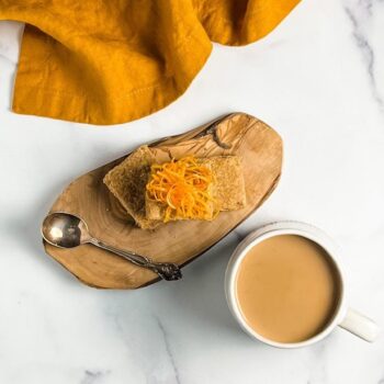 coffee shortbread on wood board with orange zest and mug of coffee
