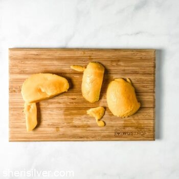peeled mango slices on a wooden cutting board