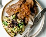 brisket with brussels salad on a ceramic plate with vintage silverware