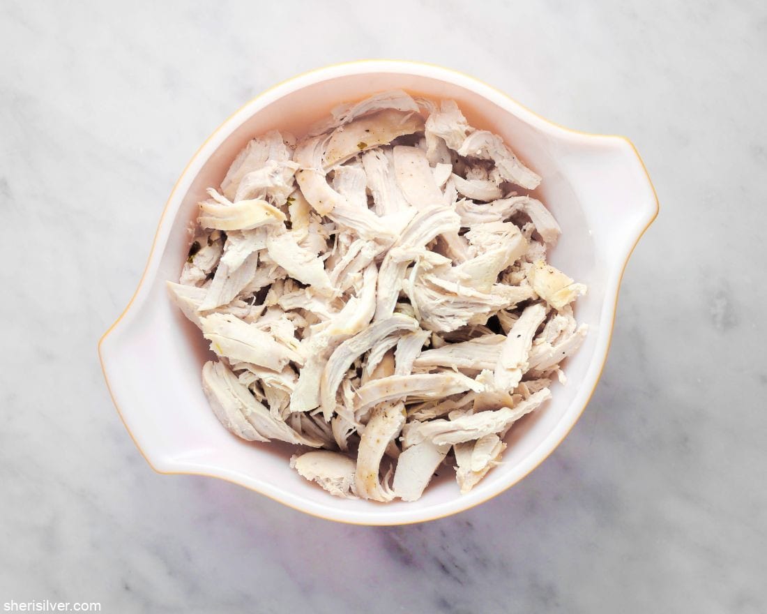 shredded chicken breasts in a vintage pyrex bowl