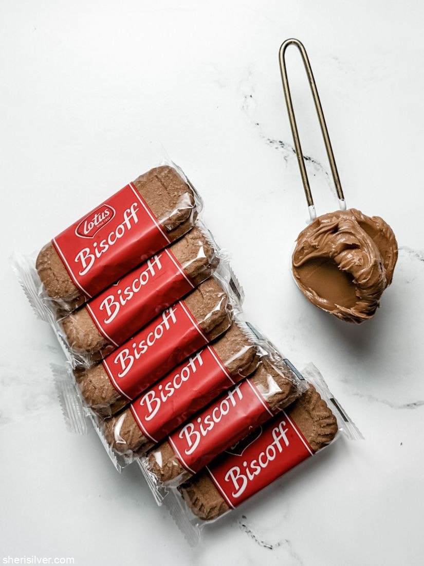 stack of biscoff cookies next to a measuring cup filled with biscoff spread