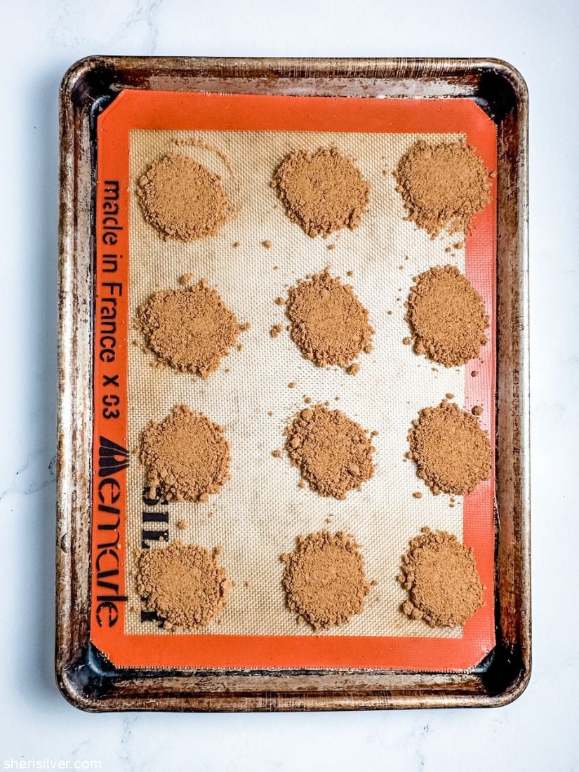crushed biscoff cookie circles on silpat lined baking sheet