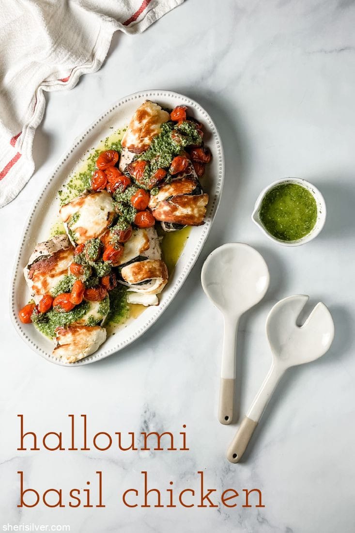 basil halloumi chicken on a ceramic platter with ceramic serving utensils