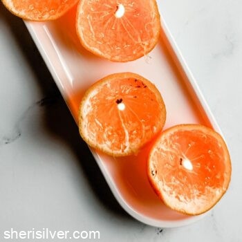clementine candles on a white ceramic tray