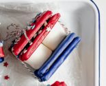 red white and blue smores wrapped in bakery twine in a white enamel tray