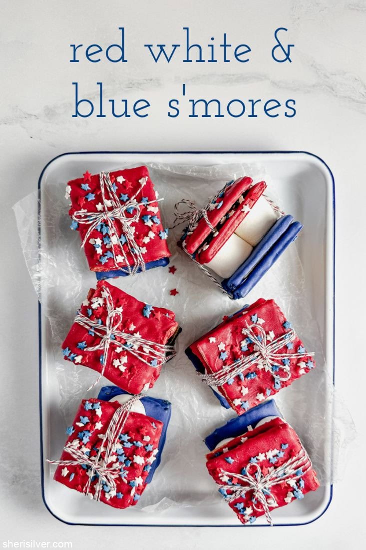red white and blue smores wrapped in bakery twine in a white enamel tray
