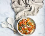 roasted pepper panzanella in a ceramic bowl with serving fork and spoon and linen napkin
