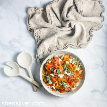 roasted pepper panzanella in a ceramic bowl with serving fork and spoon and linen napkin