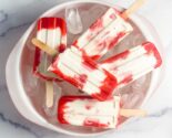 strawberries and cream popsicles in a bowl of ice