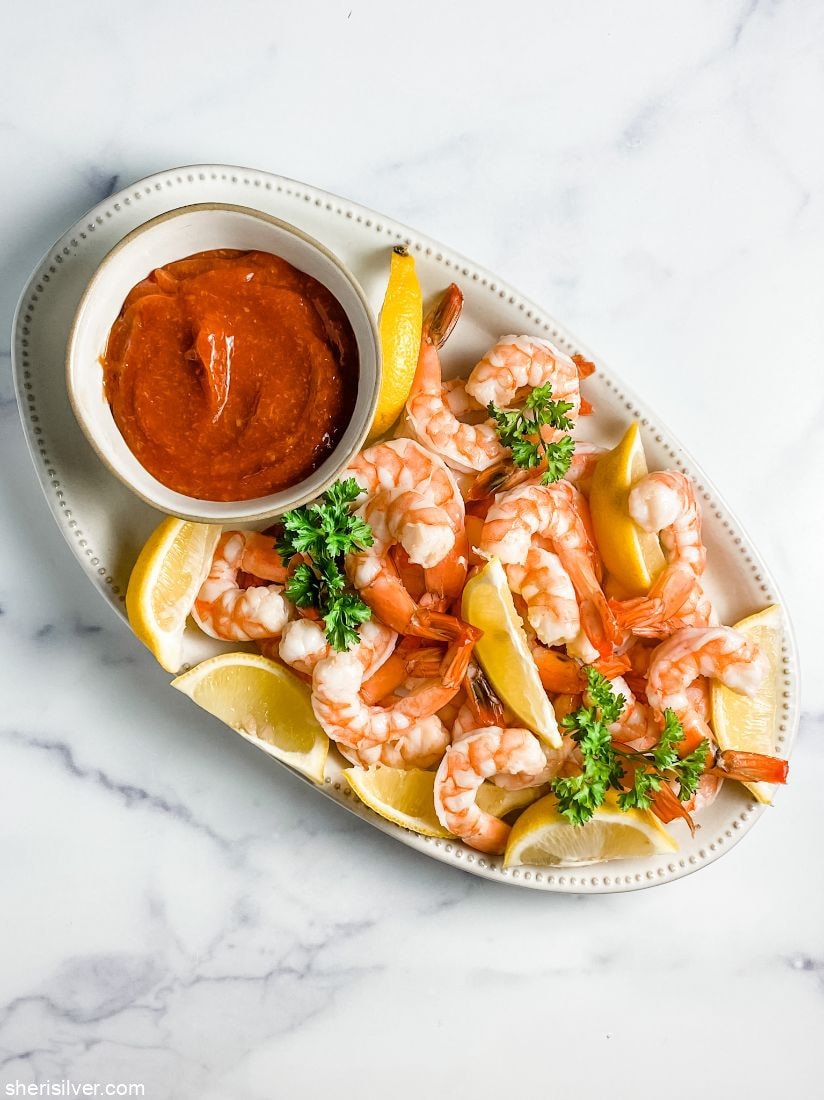 poached shrimp with cocktail sauce and lemon wedges