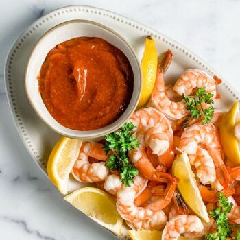 poached shrimp with cocktail sauce and lemon wedges