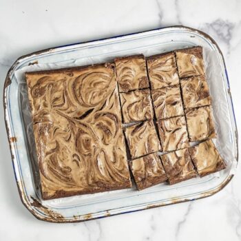 mocha cheesecake brownies on a vintage enamel tray
