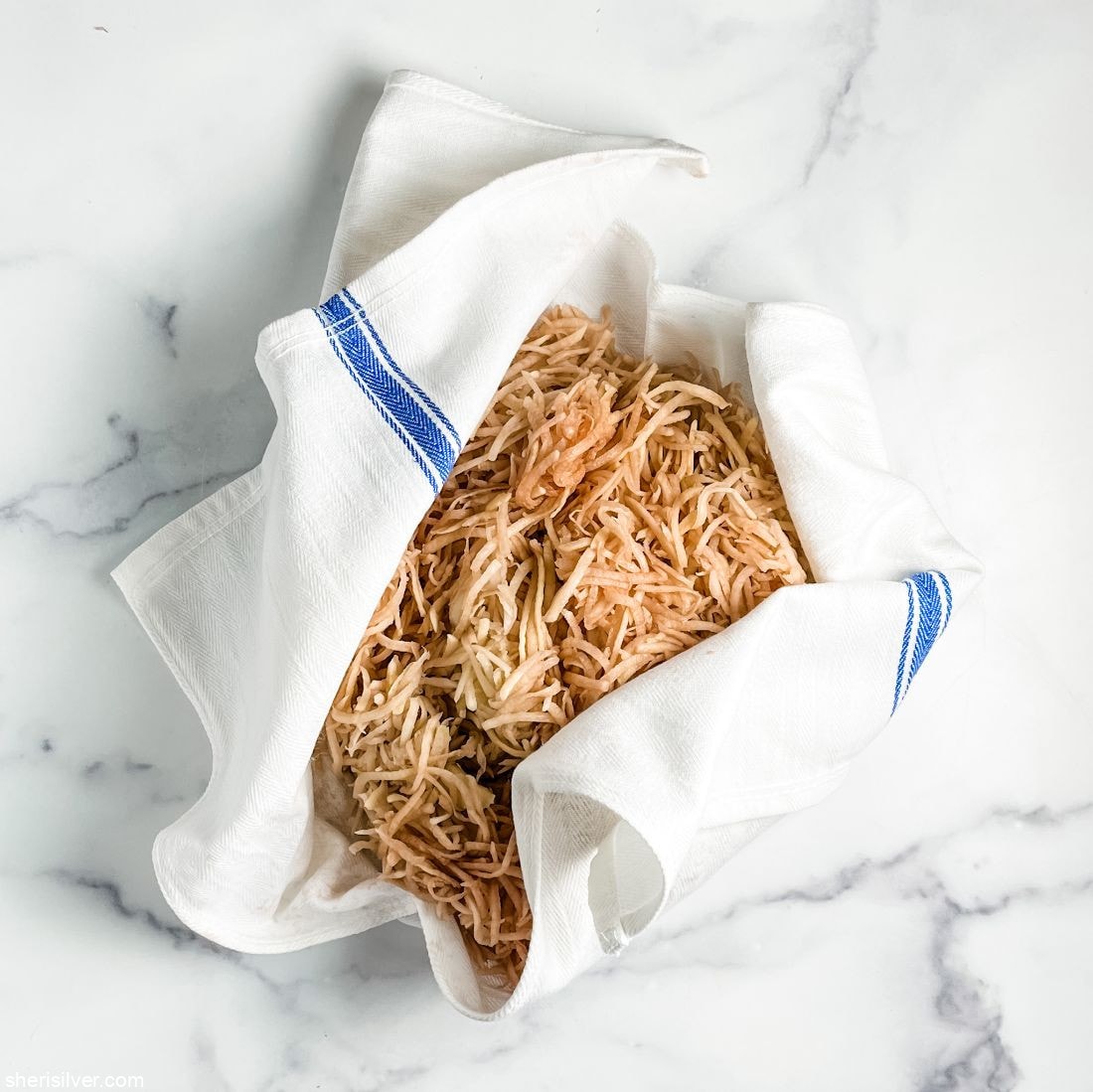 shredded potatoes in a tea towel