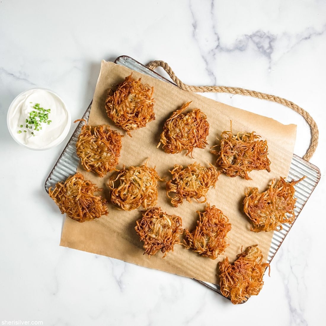 potato latkes on a tray with sour cream