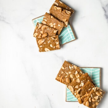 cashew toffee bars on blue coasters