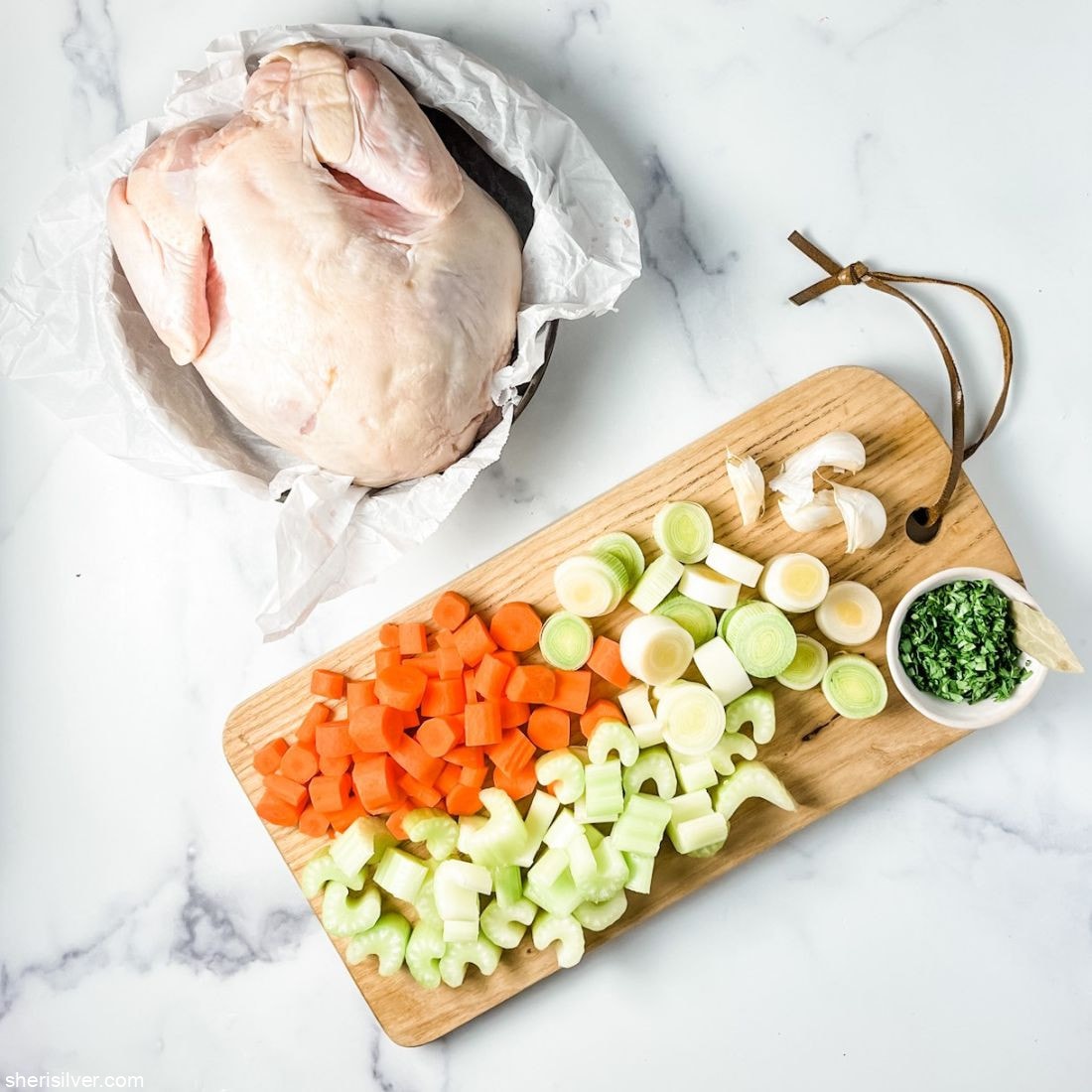 raw chicken with vegetables on a cutting board