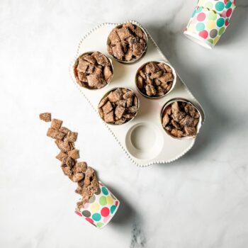 churro muddy buddies in polka dot cups in a ceramic muffin tin