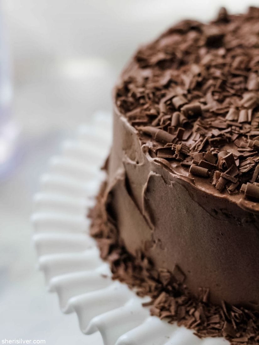 chocolate crunch layer cake on a milk glass cake plate