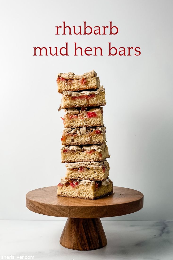 rhubarb mud hen bars on a wooden cake stand