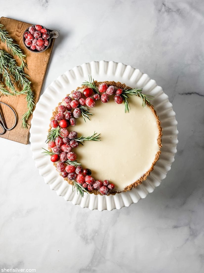 white chocolate cranberry tart on a vintage milk glass cake stand