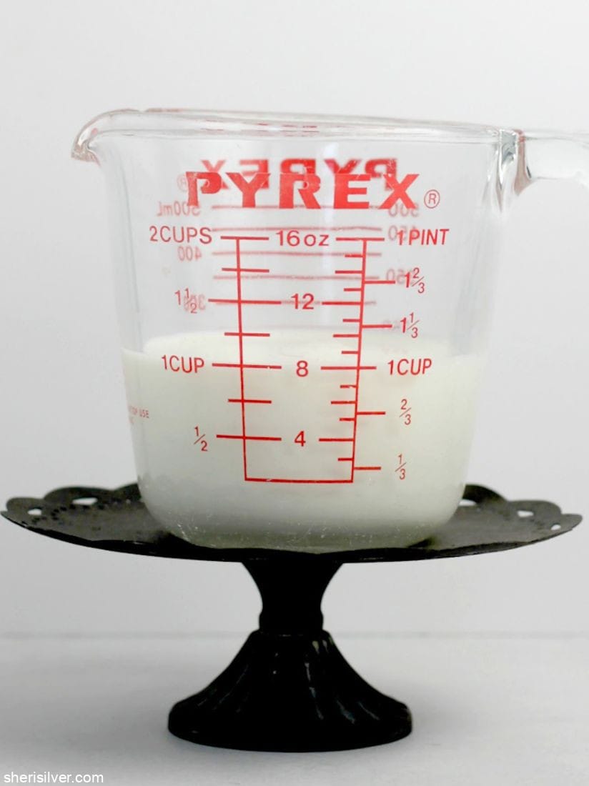 pyrex measuring cup filled with milk atop a metal cake stand