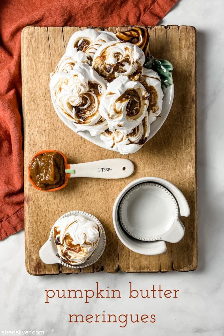 pumpkin butter meringues on a pumpkin plate next to a pumpkin spoon filled with pumpkin butter
