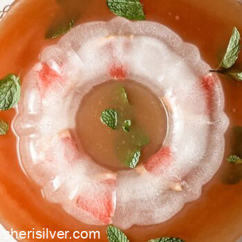 bourbon grapefruit punch in a punch bowl with ice ring and mint sprigs