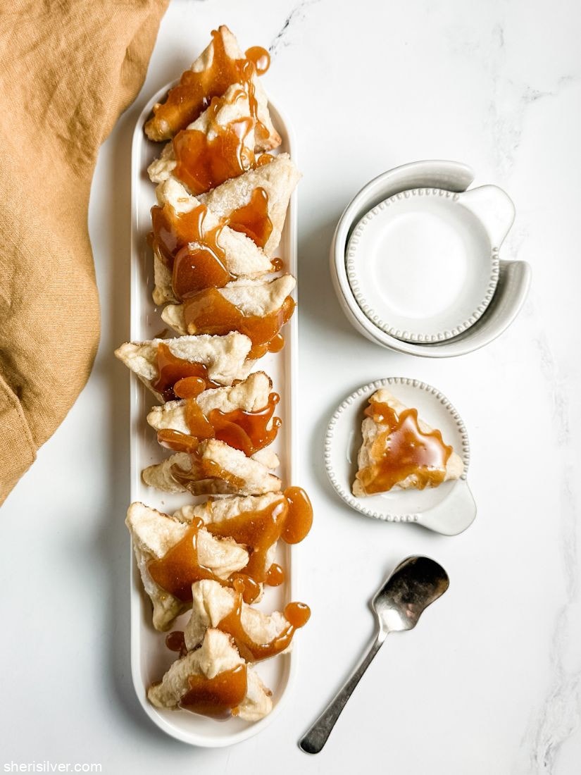 creme brulee hamantaschen on white ceramic tray and plate next to linen napkin