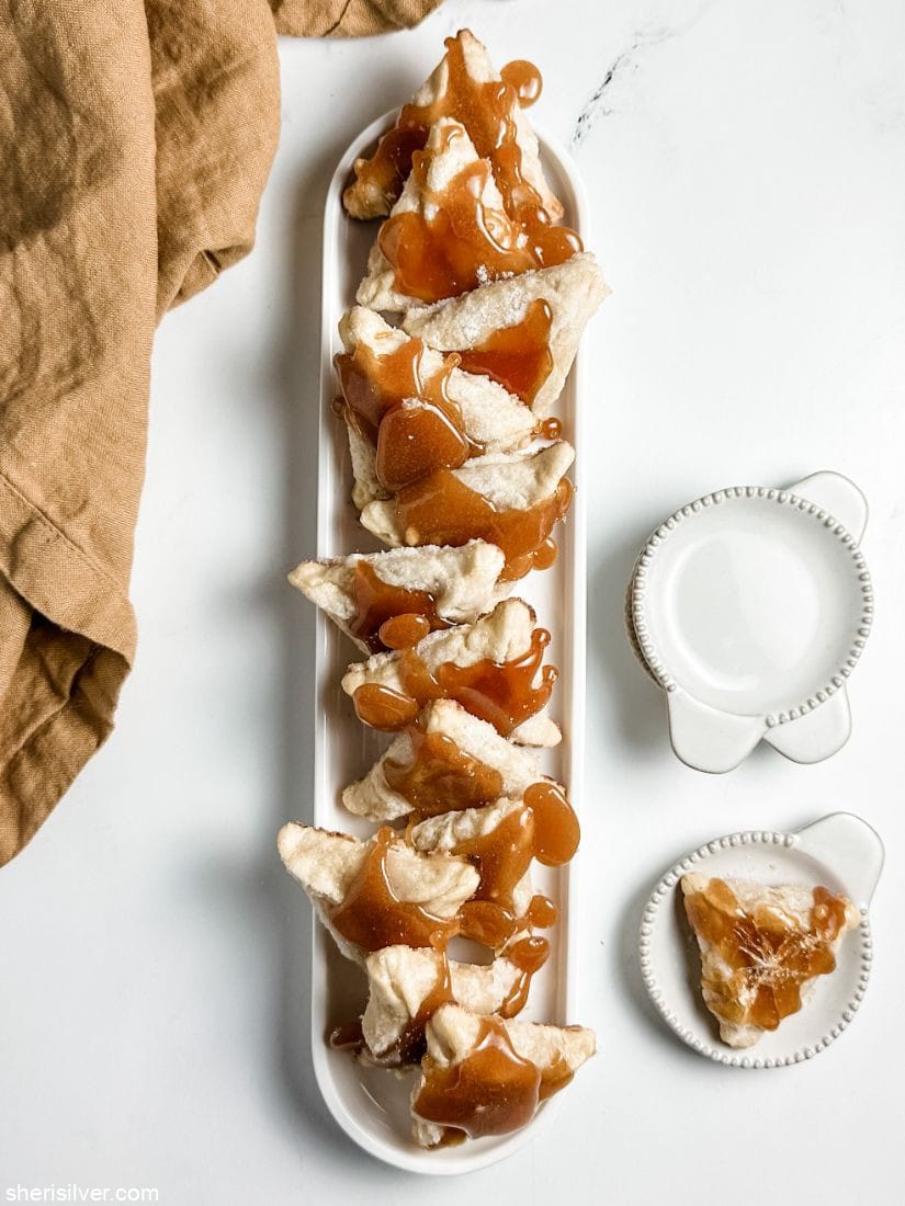 creme brulee hamantaschen on white ceramic tray and plate next to linen napkin