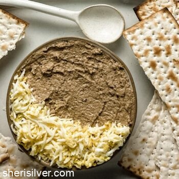 mock chopped liver in a ceramic bowl with ceramic spoon and matzoh