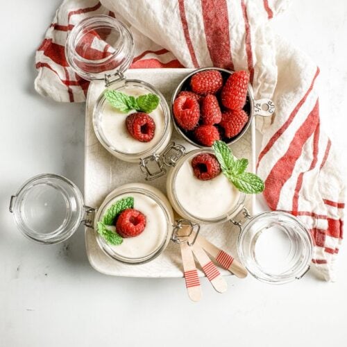 vanilla bean pudding in glass ramekins in a ceramic tray