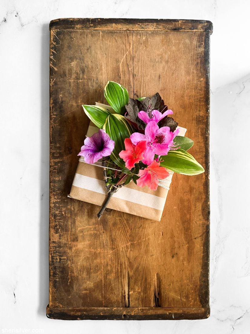 nature weaving on a wrapped present set on a wooden board