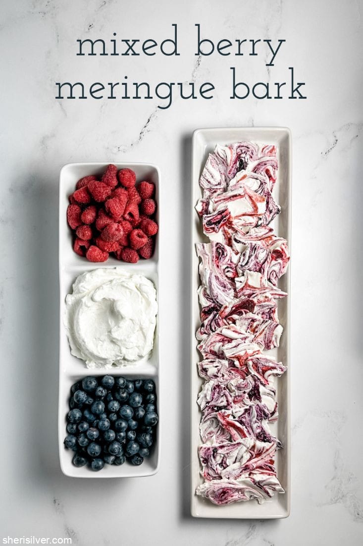 berries and whipped cream in a divided ceramic tray next to a tray of berry meringue bark