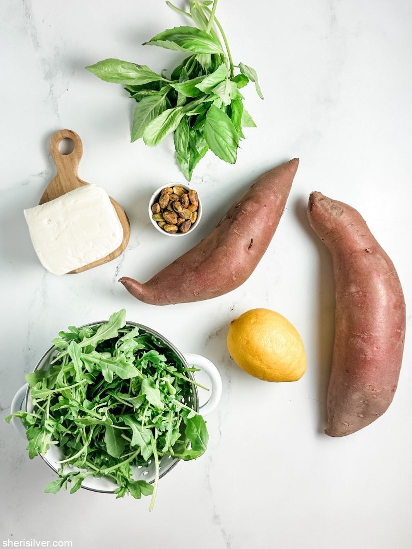 sweet potatoes next to a lemon halloumi cheese baby arugula and a bunch of basil