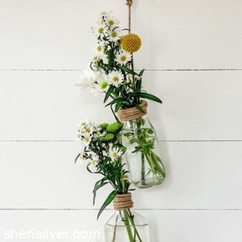 upcycled hanging vases on a shiplap wall