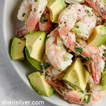 shrimp salad on a white plate with vintage flatware