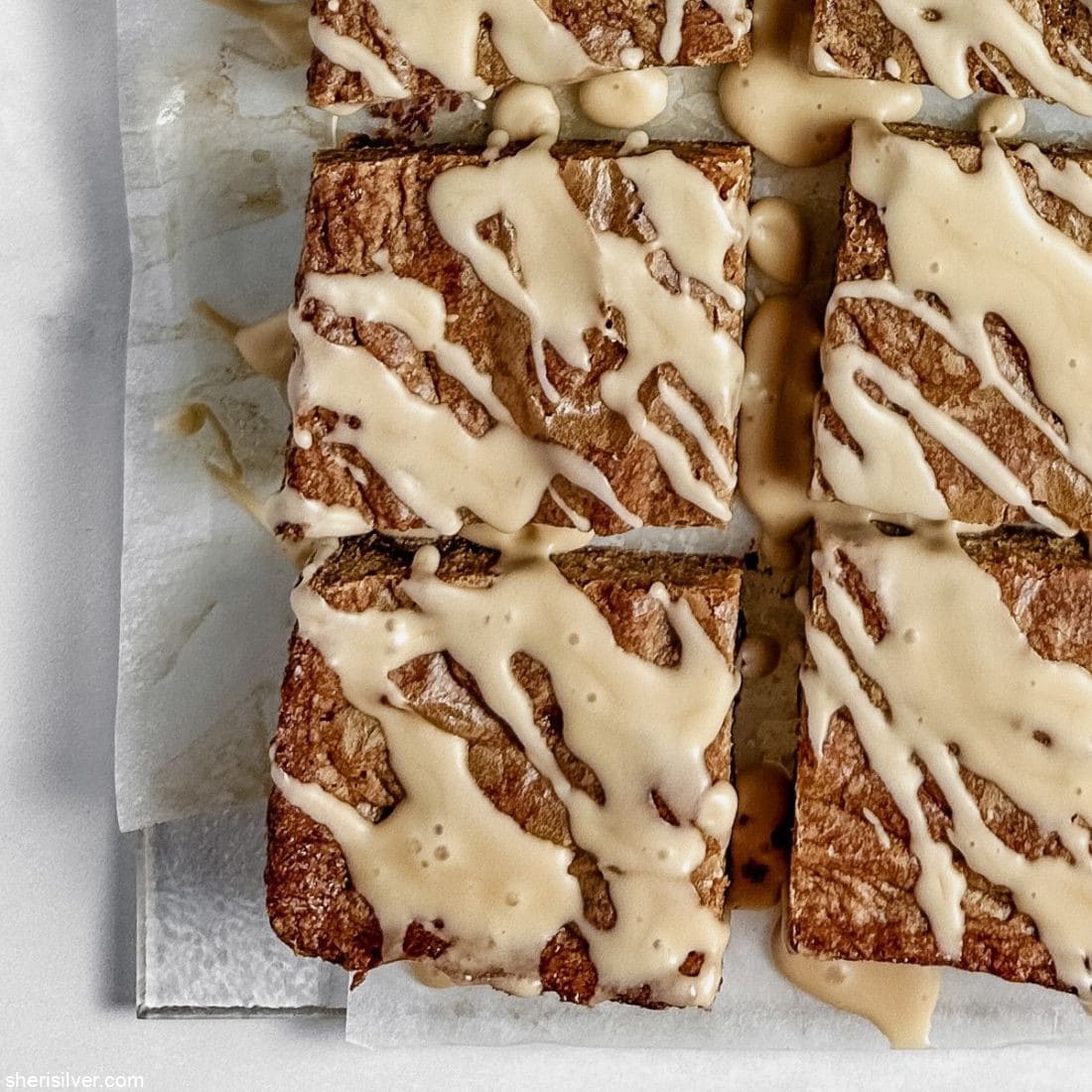 mocha chip blondies with coffee glaze on parchment paper