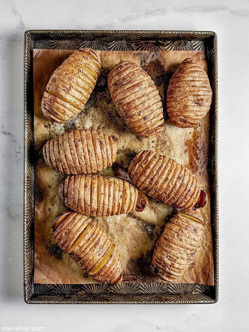 hasselback potatoes on a parchment lined baking sheet