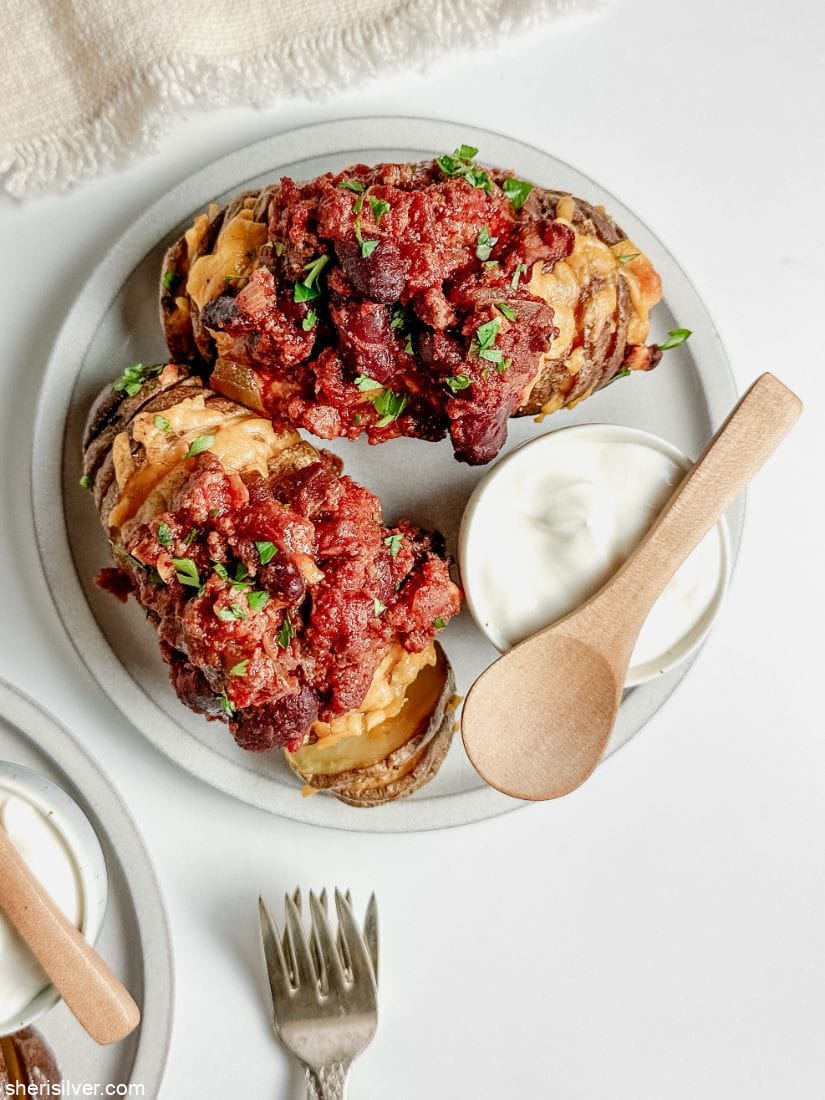 chili with hasselback potatoes on a white plate