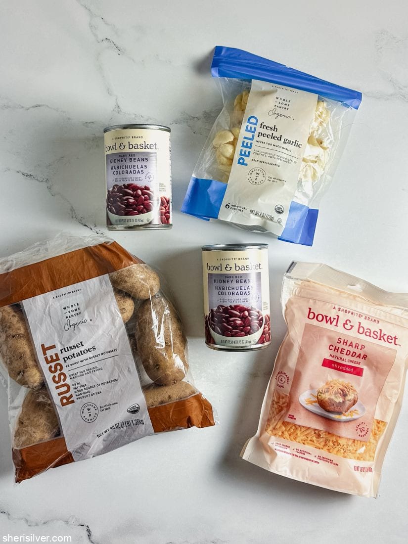 bags of shredded cheese garlic and potatoes next to cans of kidney beans