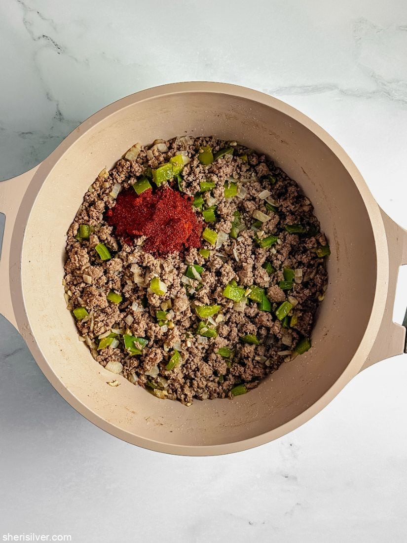 browned ground beef in a pot with chili powder