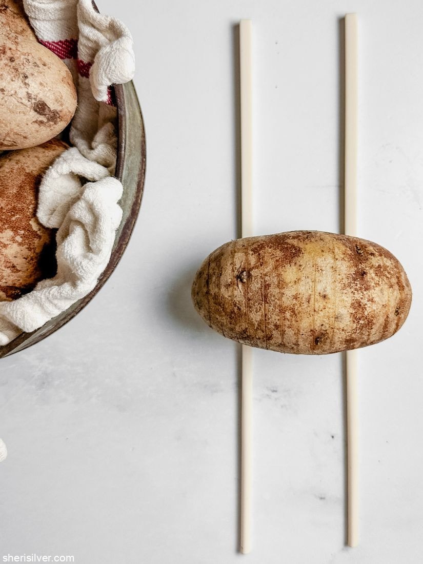 a potato on top of two chopsticks