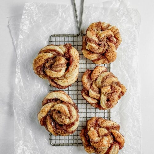 puff pastry spirals on a safety grater on crumpled wax paper
