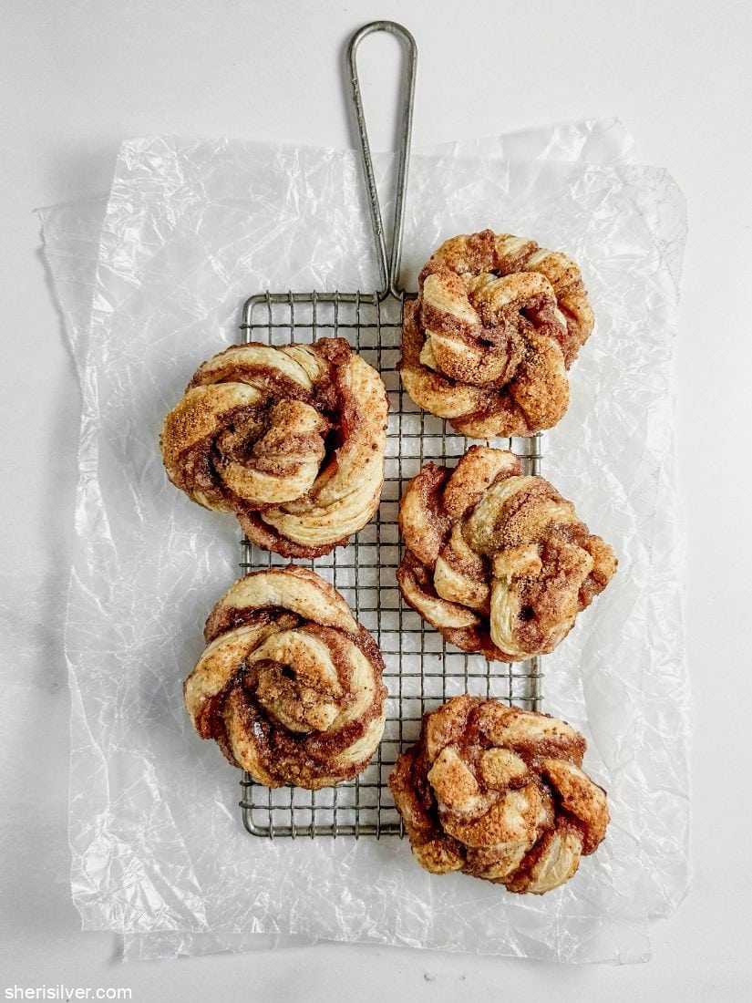 puff pastry spirals on a safety grater on crumpled wax paper