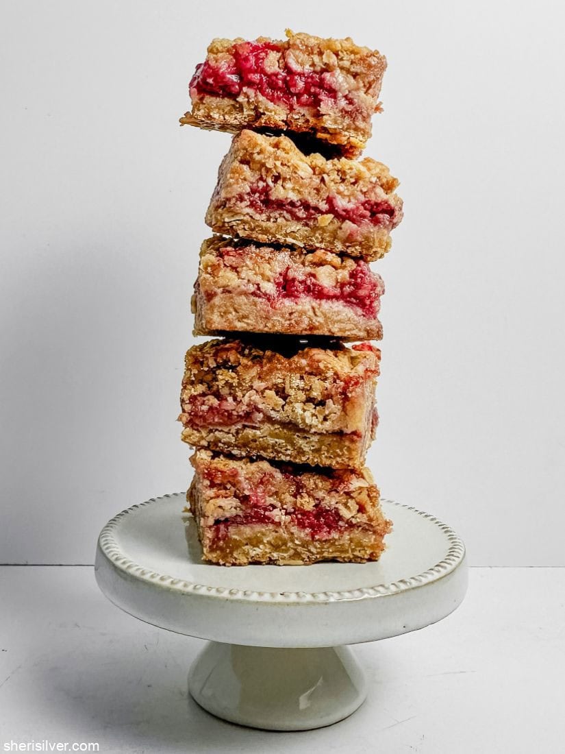 Raspberry oat squares stacked on a mini cake stand