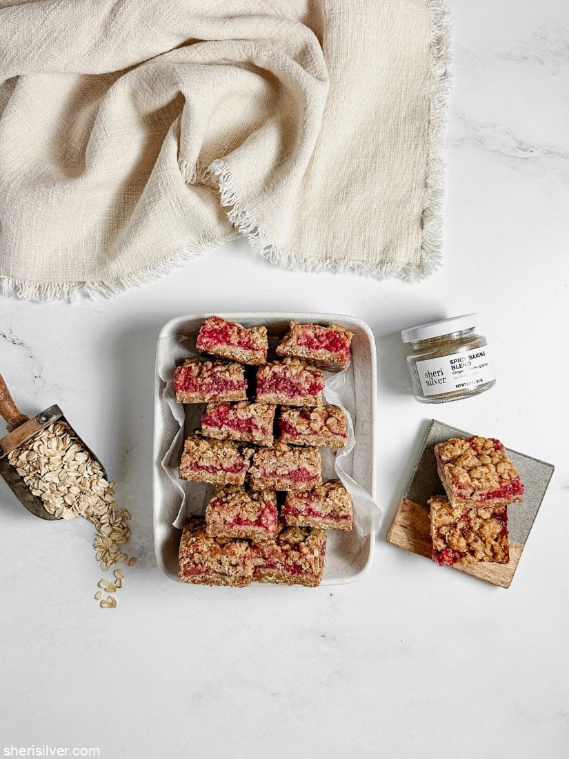 Raspberry oat squares in a parchment lined ceramic dish